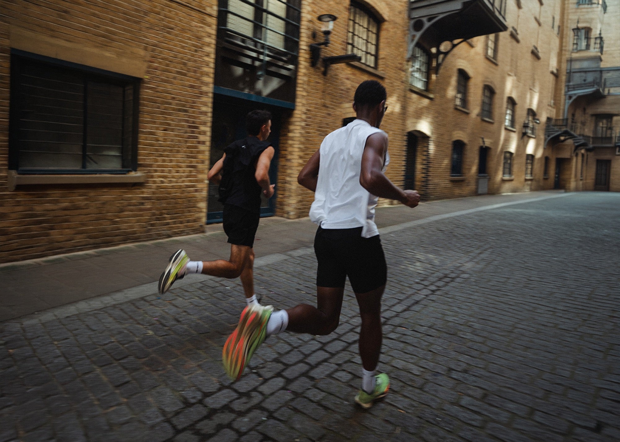 Two runners on a cobblestone street